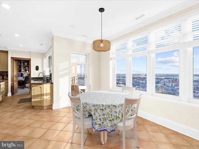 dining area featuring ornamental molding, sink, and light tile patterned floors