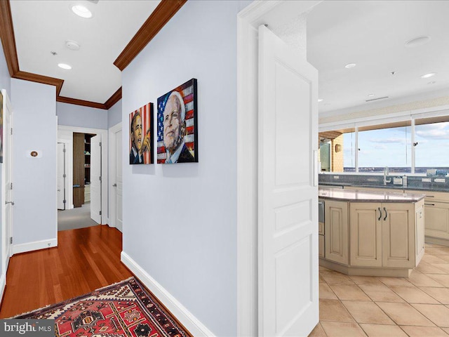 hallway featuring crown molding and light tile patterned floors