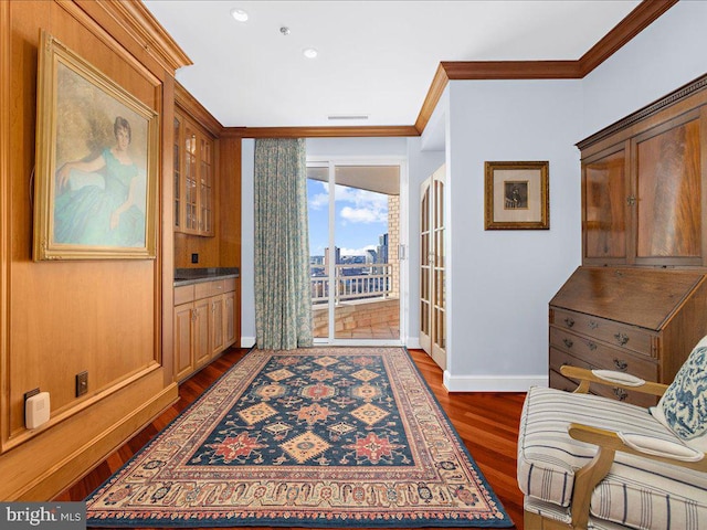 entryway with dark wood-type flooring and ornamental molding