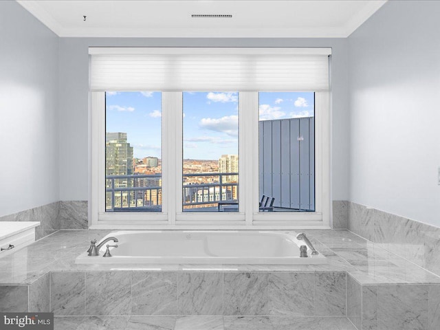 bathroom with crown molding and tiled bath