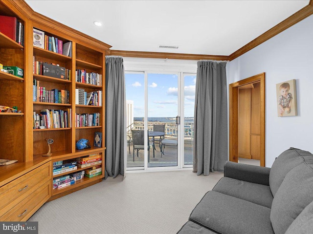 sitting room featuring ornamental molding and light colored carpet