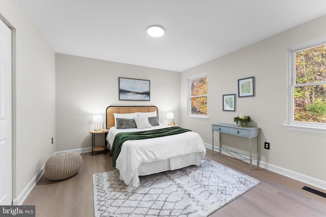 bedroom with light wood-type flooring and multiple windows