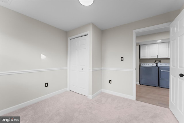 interior space with light colored carpet, independent washer and dryer, and a closet