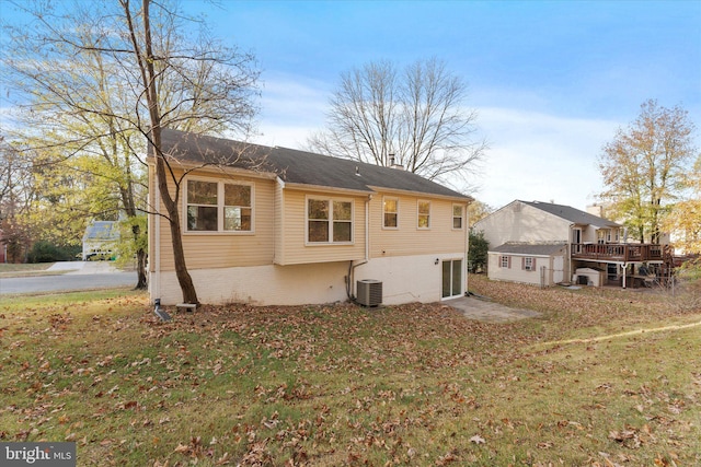 rear view of house with a yard, an outbuilding, and central AC unit