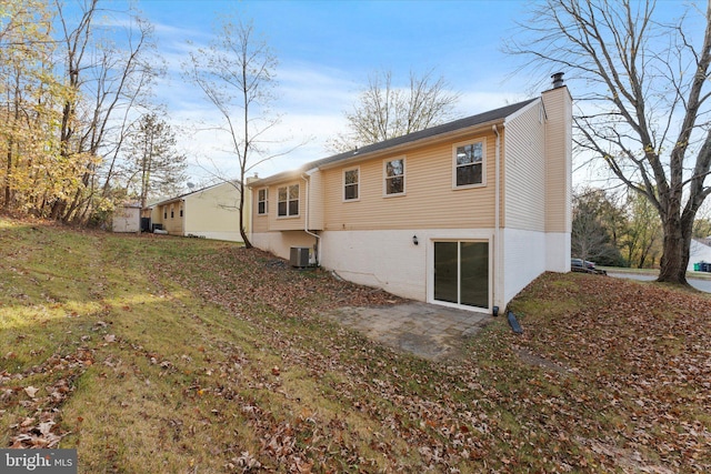 rear view of property featuring central AC and a yard