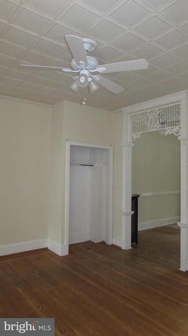 unfurnished bedroom with ceiling fan, dark wood-type flooring, and a closet