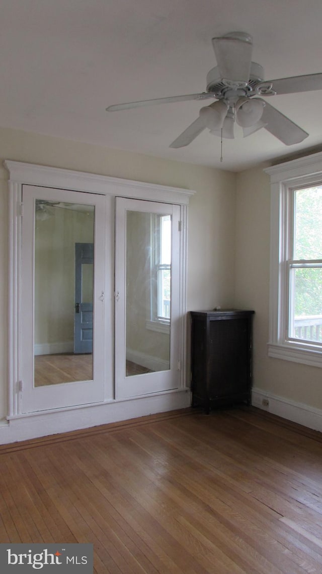 unfurnished living room with ceiling fan, light hardwood / wood-style floors, and french doors