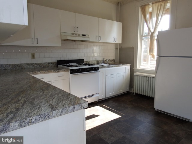 kitchen featuring white appliances, white cabinets, radiator heating unit, decorative backsplash, and sink