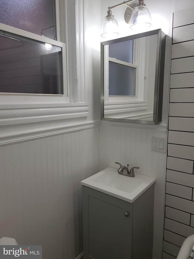 bathroom featuring vanity and wooden walls