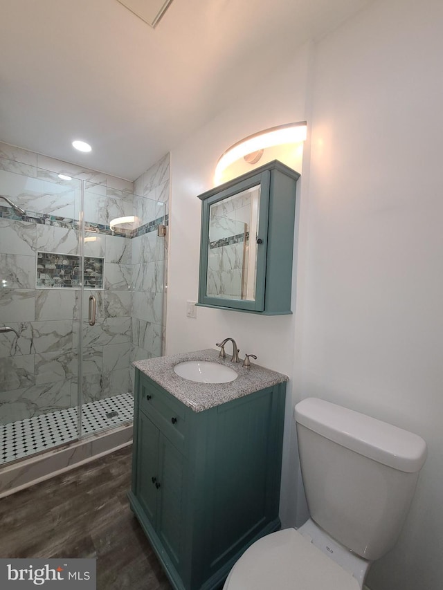 bathroom with toilet, vanity, walk in shower, and hardwood / wood-style flooring