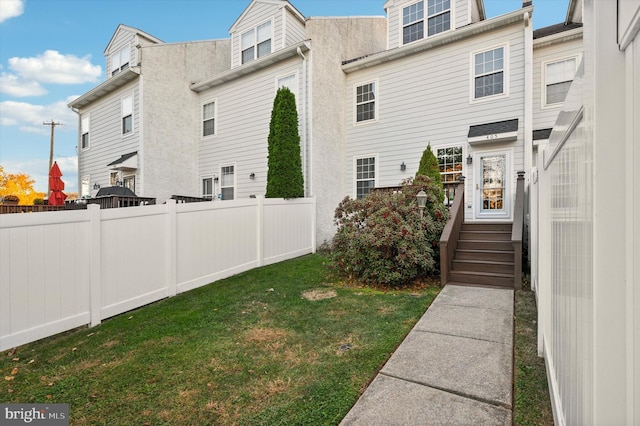 exterior space featuring a lawn and an AC wall unit