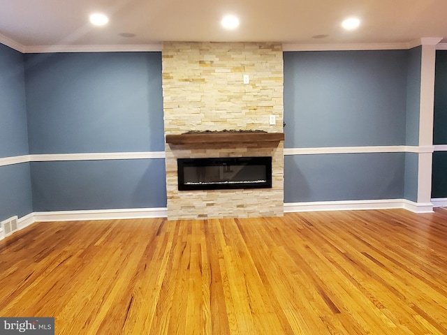 unfurnished living room with crown molding, a fireplace, and light hardwood / wood-style floors