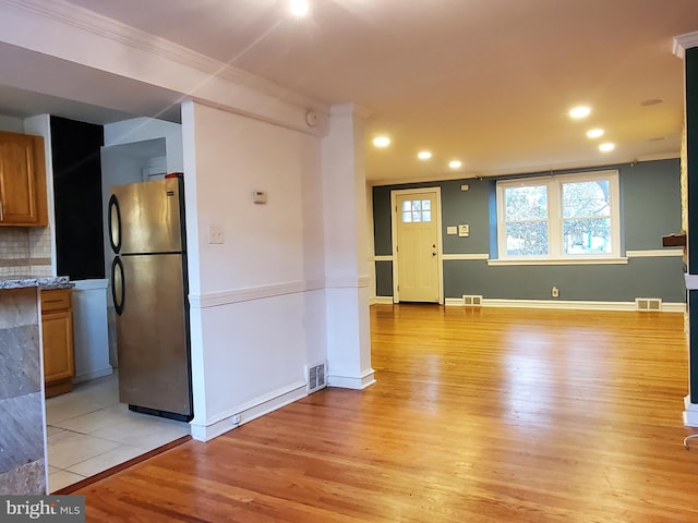 interior space with light hardwood / wood-style flooring and ornamental molding