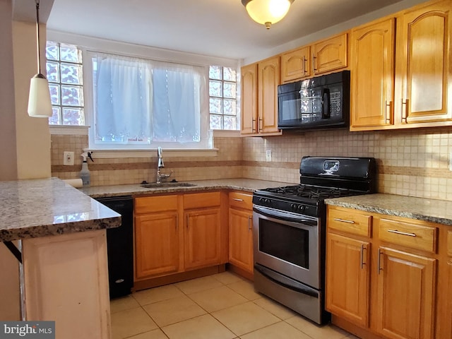 kitchen featuring light stone counters, light tile patterned floors, backsplash, black appliances, and sink