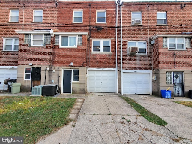 exterior space with cooling unit, a garage, and central air condition unit