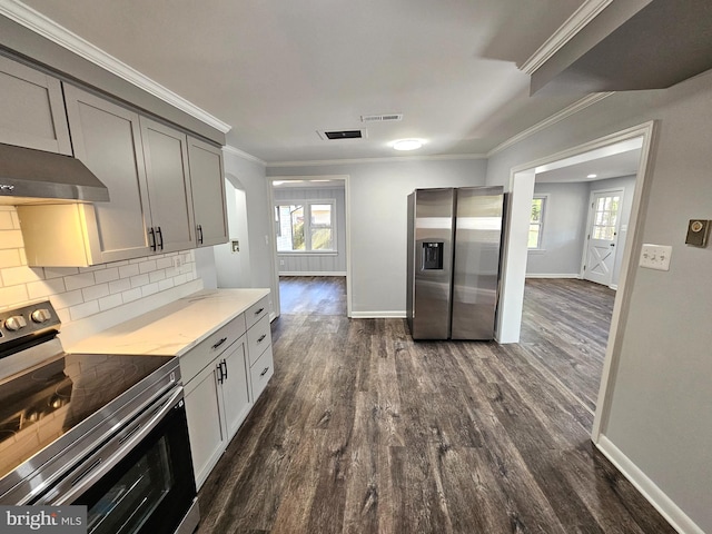 kitchen with appliances with stainless steel finishes, tasteful backsplash, a wealth of natural light, and gray cabinetry