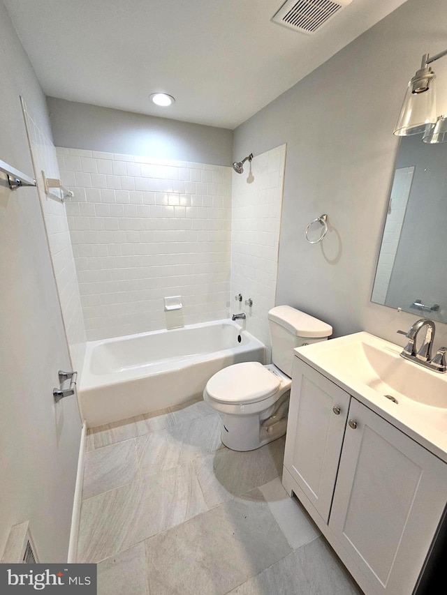 full bathroom with vanity, tiled shower / bath combo, and toilet