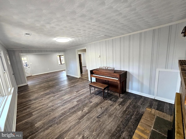 misc room featuring a textured ceiling, dark hardwood / wood-style floors, and ornamental molding