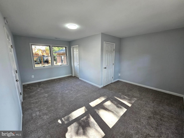 unfurnished bedroom featuring a closet and dark colored carpet