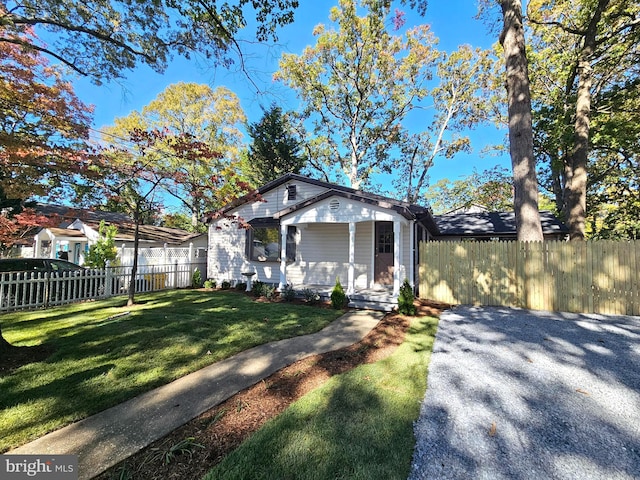 bungalow-style house with covered porch and a front lawn