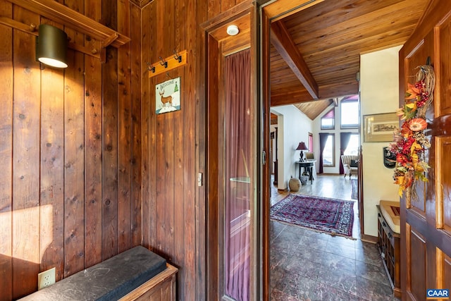 corridor featuring vaulted ceiling with beams, wood walls, and wooden ceiling