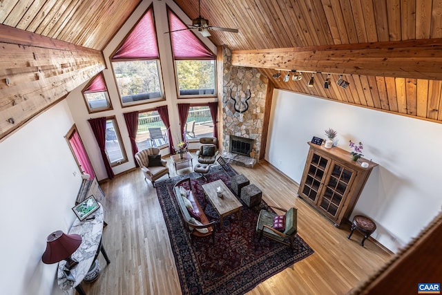 living room with wooden ceiling, hardwood / wood-style floors, a fireplace, high vaulted ceiling, and ceiling fan