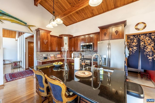 kitchen featuring beam ceiling, appliances with stainless steel finishes, wood ceiling, and dark hardwood / wood-style floors