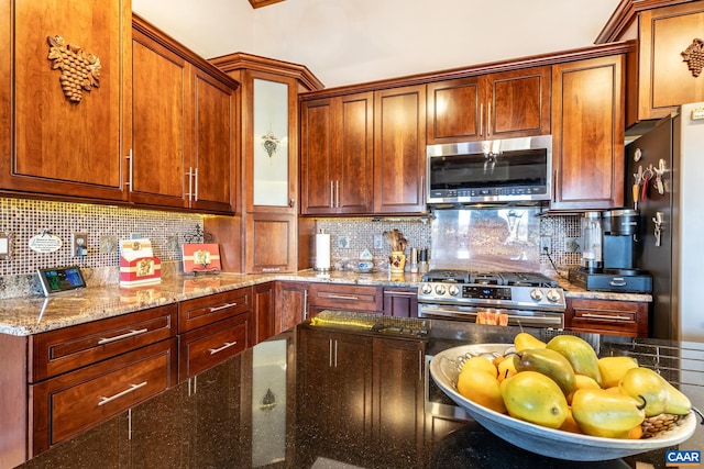 kitchen with light stone countertops, decorative backsplash, and appliances with stainless steel finishes