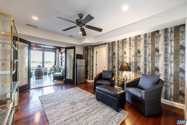 living area featuring dark hardwood / wood-style floors and ceiling fan