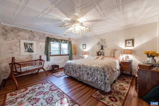 bedroom with crown molding, wood-type flooring, and ceiling fan