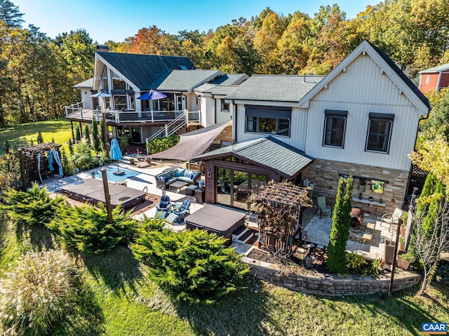 rear view of property with a patio, a swimming pool side deck, outdoor lounge area, and a yard