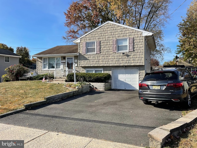 tri-level home with a garage and a front yard