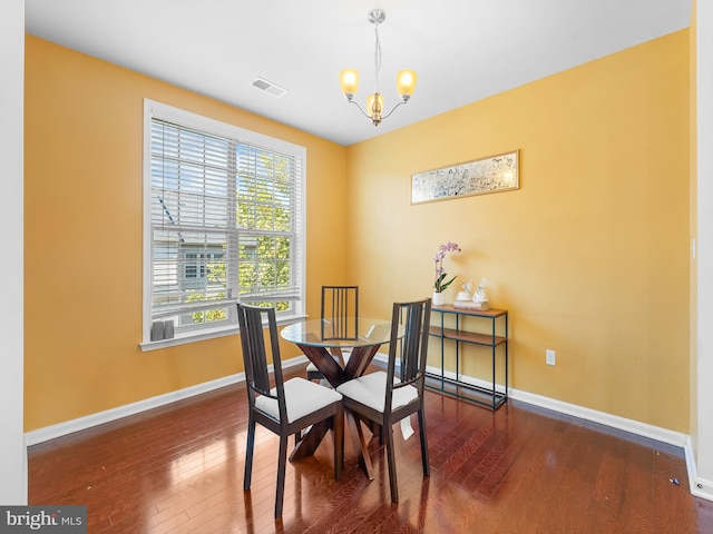 dining area with a notable chandelier and dark hardwood / wood-style flooring