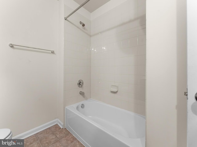 bathroom featuring tile patterned floors, tiled shower / bath combo, and toilet