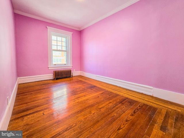 empty room featuring ornamental molding, radiator heating unit, and hardwood / wood-style floors