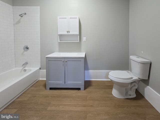 full bathroom featuring vanity, tiled shower / bath combo, wood-type flooring, and toilet