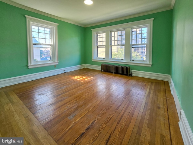 unfurnished room with crown molding, hardwood / wood-style flooring, and radiator heating unit