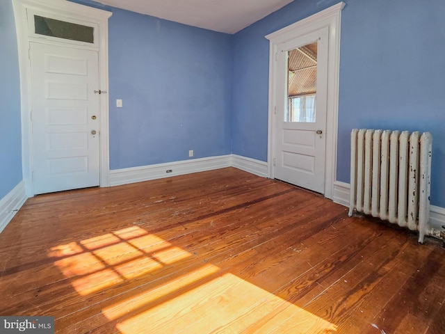 spare room with radiator and hardwood / wood-style flooring