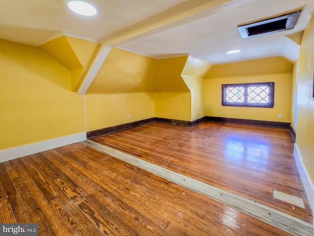 additional living space with lofted ceiling and hardwood / wood-style flooring