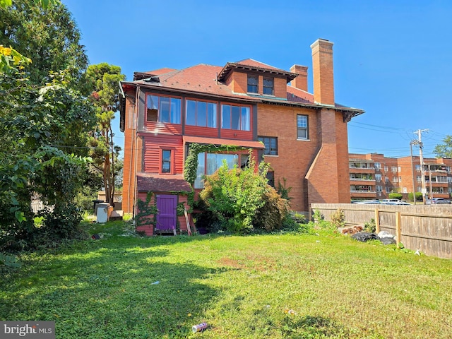 rear view of house featuring a lawn