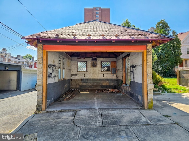 view of patio / terrace featuring a garage and an outbuilding