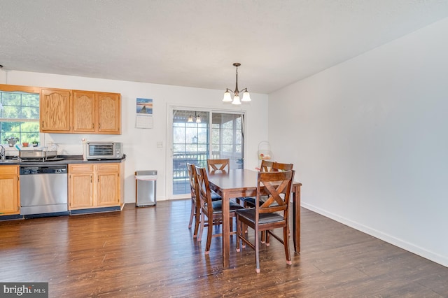 dining room featuring dark hardwood / wood-style flooring, a wealth of natural light, and an inviting chandelier