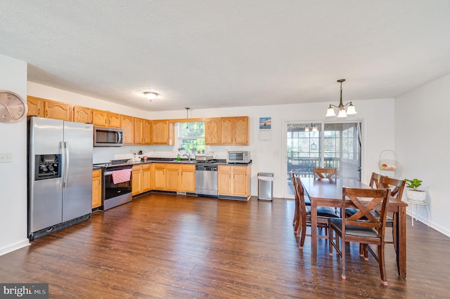 kitchen featuring sink, hanging light fixtures, dark hardwood / wood-style floors, a chandelier, and appliances with stainless steel finishes