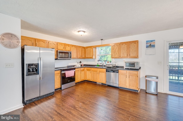 kitchen featuring sink, dark wood-type flooring, a textured ceiling, and appliances with stainless steel finishes