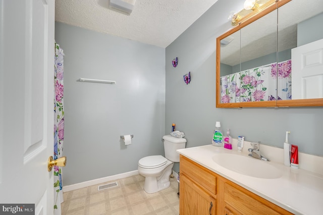 bathroom with vanity, a textured ceiling, and toilet