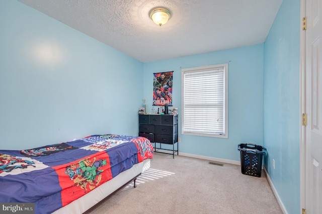 bedroom featuring a textured ceiling and light colored carpet