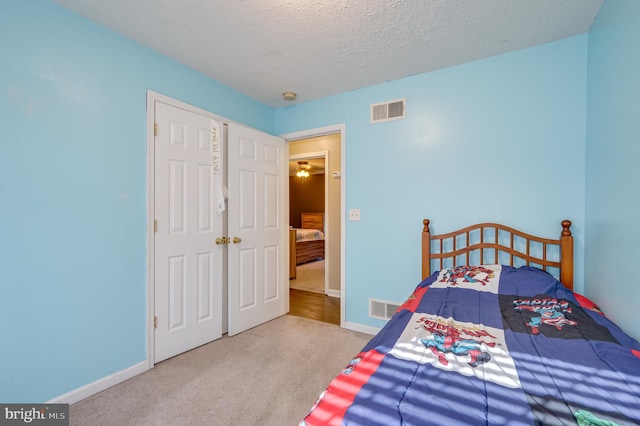 carpeted bedroom featuring a textured ceiling