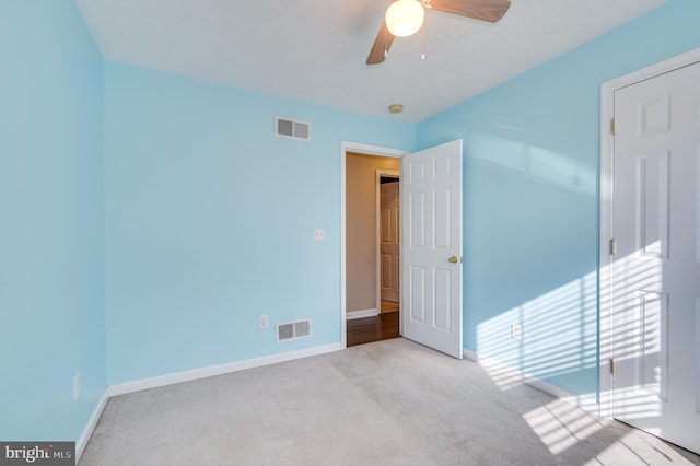 carpeted empty room featuring ceiling fan