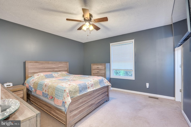 carpeted bedroom with a textured ceiling and ceiling fan