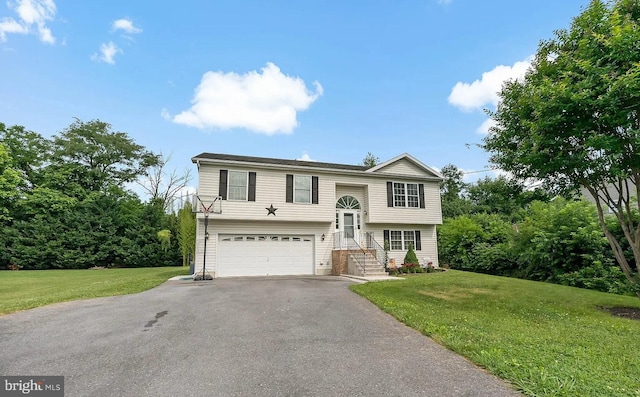 raised ranch with a garage and a front lawn